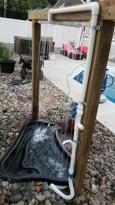 an outdoor shower with water coming out of it and hoses attached to the side