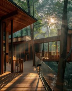 the sun shines through the trees in front of a house with wooden decking