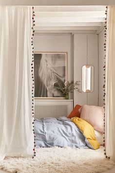 a bedroom with a white canopy bed and rugs on the floor next to it