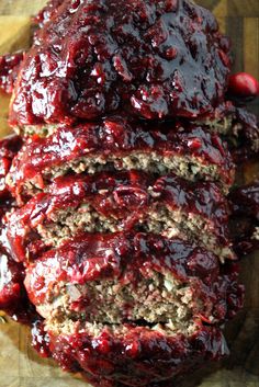 sliced meatloaf with cranberry sauce on a cutting board, ready to be eaten