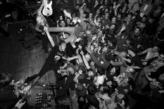 a group of people that are standing in front of a guitar and some microphones