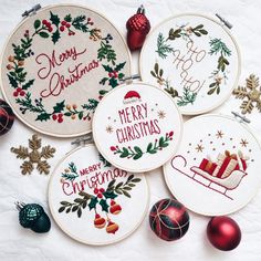 four embroidered christmas ornaments are arranged on a white surface