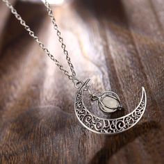 Made for the ones who adore that lunar beauty up above. This necklace is highlighted by a glow-in-the-dark orb. The glowing pendant is wrapped by an intricately woven enclosure which artfully dangles next to a rustic crescent moon. The orb absorbs natural light and uses it to glow in the dark. The crescent moon details enchanting ancient patterns that resemble the phases of the moon. Wear this necklace to Halloween, Full Moon Parties or to Mid-Autumn Festival. It is simply that piece of jeweller Moonglow Necklace, Lunar Beauty, Moon Goddess Necklace, Glowing Necklace, Goddess Necklace, Christmas Necklace, Crescent Moon Necklace, Rare Gemstones, Moonstone Necklace