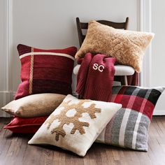 a pile of pillows sitting on top of a wooden floor