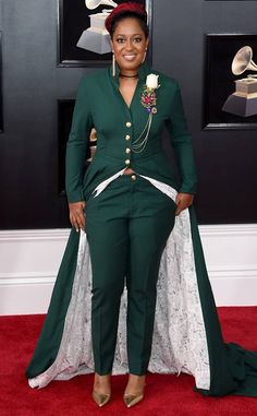 a woman in a green suit standing on a red carpet