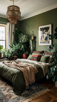 a bedroom with green walls and lots of plants in the corner, along with a large bed