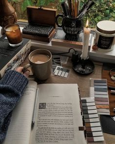 an open book sitting on top of a table next to a cup of coffee