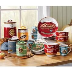 a kitchen counter topped with lots of cups and saucers next to a window filled with pumpkins