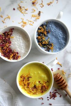 three bowls filled with different types of food on top of a white tablecloth next to a honey comb