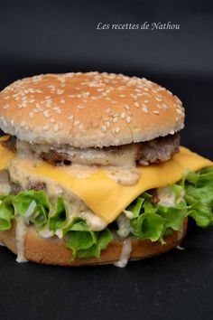 a cheeseburger with lettuce and other toppings on a black surface