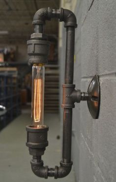 an industrial style light fixture hanging from the side of a building