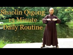 a man standing on top of a wooden dock next to a lake and trees with the words shaolin ogong 15 minute daily routine