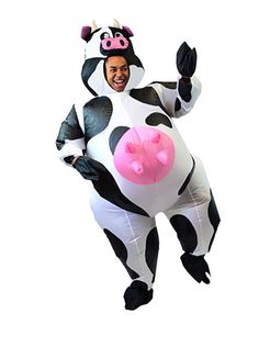 a man in a cow costume is flying through the air with his hands up and smiling