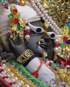 a close up of a statue with pearls on it's face and headdress