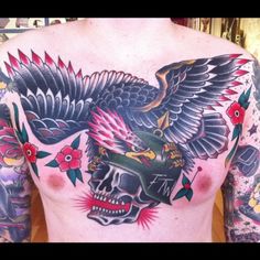 a man's chest with an eagle and skull tattoo design on it is shown