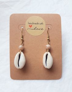 *Discover our magnificent natural cowrie shell and sunstone earrings, entirely handmade with love. Gold-tone stainless steel ear hooks add a touch of elegance to this unique jewelry. These earrings evoke the spirit of the beach, summer and vacation, and are the perfect addition to any summer outfit. Cowrie shells add a natural, boho touch, while sunstones catch the light and brighten your face. Each pair is unique and will add a touch of character to your look. *Properties of Sunstone in Lithoth Sunstone Earrings, Natural Boho, Cowrie Shells, Natural Stone Jewelry, Jewellery Ideas, Joy Of Life, Cowrie Shell, Shell Earrings, Vacation Beach