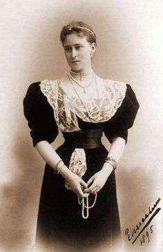 an old black and white photo of a woman wearing a dress with lace on it