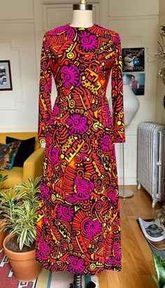 "Absolutely fantastic late 60s/early 70s bright graphic printed maxi dress, with a high neckline and long fitted sleeves. Nipped in waistline with pleating around the hips. Back zip closure with 2 snaps at the top. Made of a heavier weight rayon and poly blend. The fabric feels great for semi synthetic and theres a full cotton lining so it doesn't itch. Such a one of kind dress with an incredible print in bright pink, orange, red and yellow. Fits about a size small, has a bit of stretch 15\" sho Retro Multicolor Maxi Dress With Vibrant Print, Retro Multicolor Printed Maxi Dress, Fitted Retro Print Maxi Dress, Retro Long Sleeve Dress With Vibrant Print, Long Sleeve Dresses With Retro Print For Party, 70s Inspired Fitted Maxi Dress, Retro Long Sleeve Maxi Dress With Vintage Print, Fitted Multicolor Groovy Dress, Fitted Multicolor Retro Maxi Dress