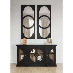 two mirrors on the wall above a black sideboard with glass doors and an open shelf