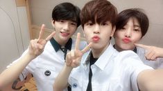 three young men posing for the camera with their fingers in the shape of two peace signs