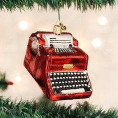 an ornament hanging from a christmas tree with a red typewriter on it