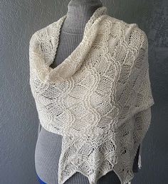 a white knitted shawl on top of a mannequin