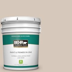 the behr paint and primer in one is shown on a brown background with white trim