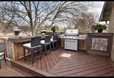 an outdoor kitchen and grill on a deck