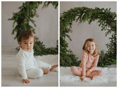 two children sitting on the floor in front of christmas wreaths