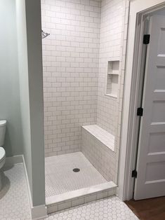 a walk in shower sitting next to a white toilet