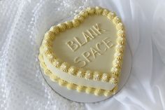 a heart shaped cake with the words blank space on it sitting on a white cloth