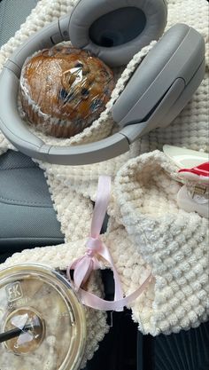 there is a cake and headphones on the car seat next to it's cup