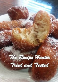 a plate topped with donuts covered in powdered sugar