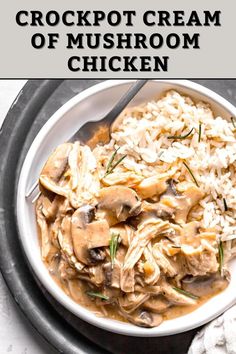 a white bowl filled with mushroom and rice on top of a metal tray next to a spoon