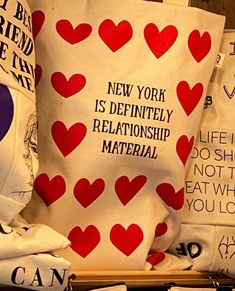 several bags with red hearts on them are sitting on a wooden table next to each other