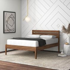 a bed sitting on top of a wooden floor next to a white and black rug