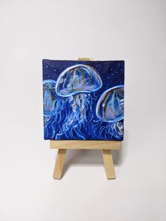 an easel with a painting of jellyfish on it