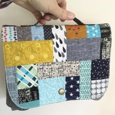 a person holding onto a multicolored patchwork purse