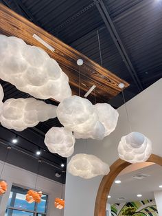 a room filled with lots of white clouds hanging from the ceiling and lights on the ceiling