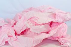 a pile of pink tissue paper sitting on top of a white table