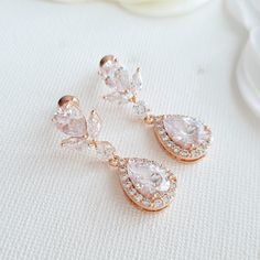 Pretty and elegant, the Emma rose gold drop earrings are mid sized and great for all day wear. Created with the rich and warm tones of rose gold, the earring for brides is made with halo set tear drops in cubic zirconia. The wedding earrings are paired up with sparkling cubic zirconia ear tops. The bridal earrings are also available in silver/rhodium finish and 14k gold finish. Material used is rose gold plated brass components. Earrings are light weight and a great length. # length of Earring f Rose Gold Drop Bridal Earrings For Anniversary, Rose Gold Teardrop Bridal Earrings For Anniversary, Rose Gold Cluster Earrings For Wedding, Rose Gold Teardrop Wedding Earrings, Ear Tops, Rose Gold Drop Earrings, Brass Components, Crystal Earrings Wedding, Emma Rose