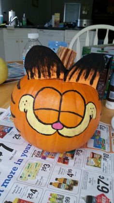 a pumpkin decorated to look like a cat's face on top of a table