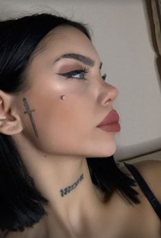 a woman with cross tattoos on her face