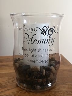 a glass vase filled with rocks on top of a wooden table