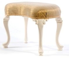 a white stool with gold fabric on the top and bottom, sitting in front of a white background