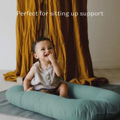 a baby sitting on a pillow with the words perfect for sitting up support written above it