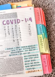 an open bible with the words covidd - 19 printed on it and colorful dividers