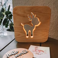 a wooden box with a laser cut out of a deer on it and some cards next to it