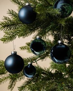 black christmas ornaments hanging from a pine tree