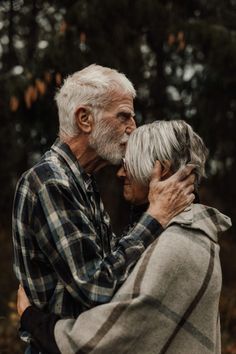 an older couple embracing each other in the woods